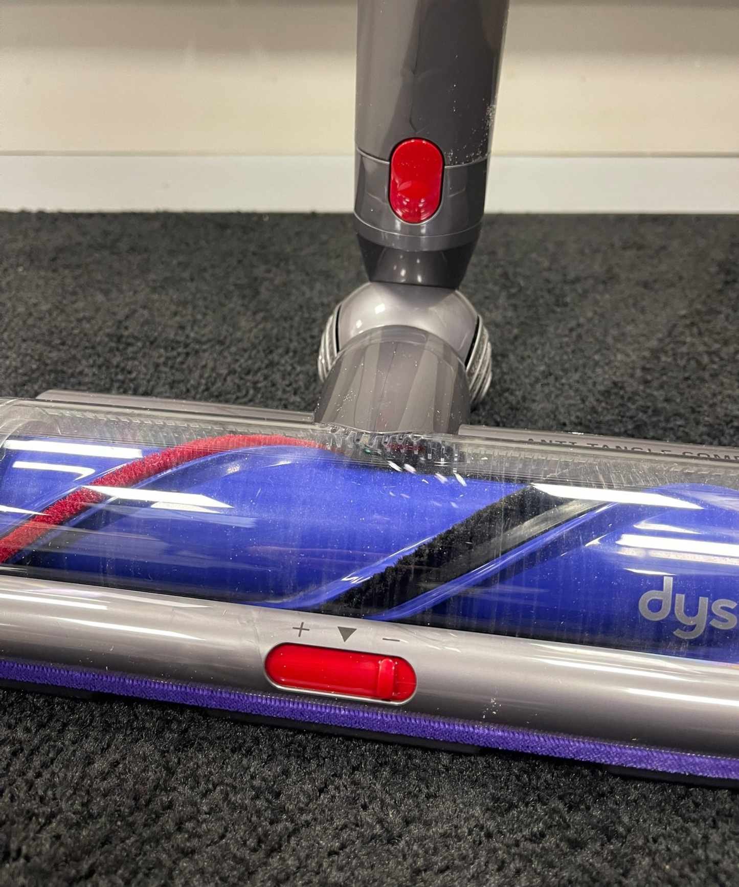 Close up of the Dyson V15 Detect's purple and gray Digital Motorbar floorhead on carpet in Future test center