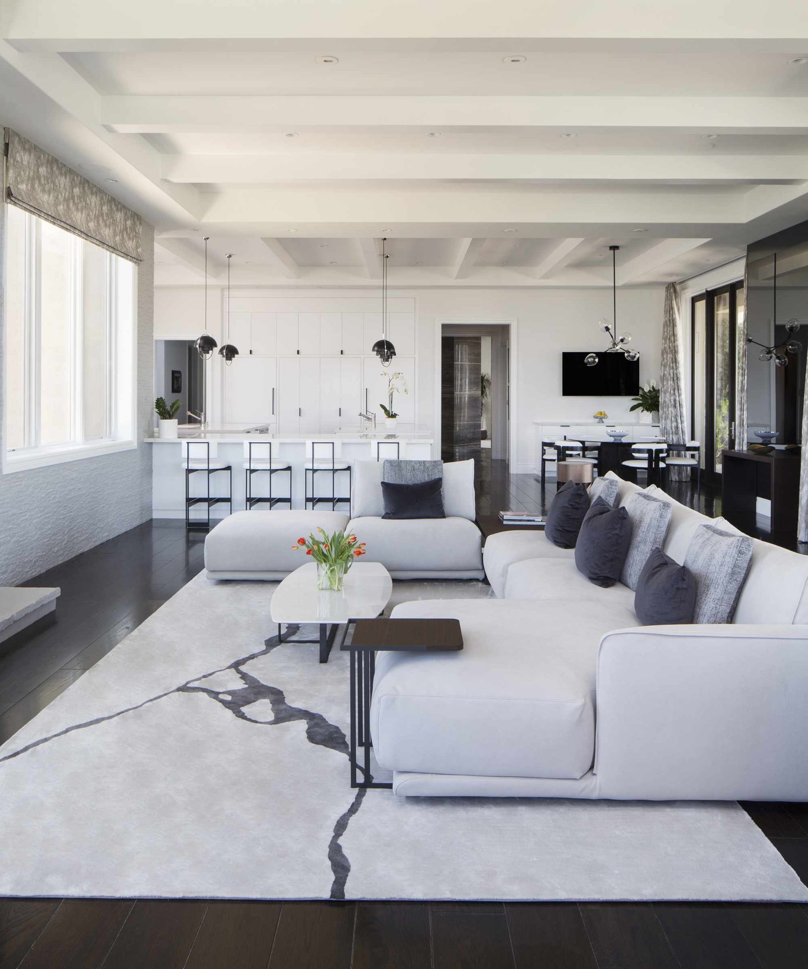 A white family room in an open-plan living and kitchen space