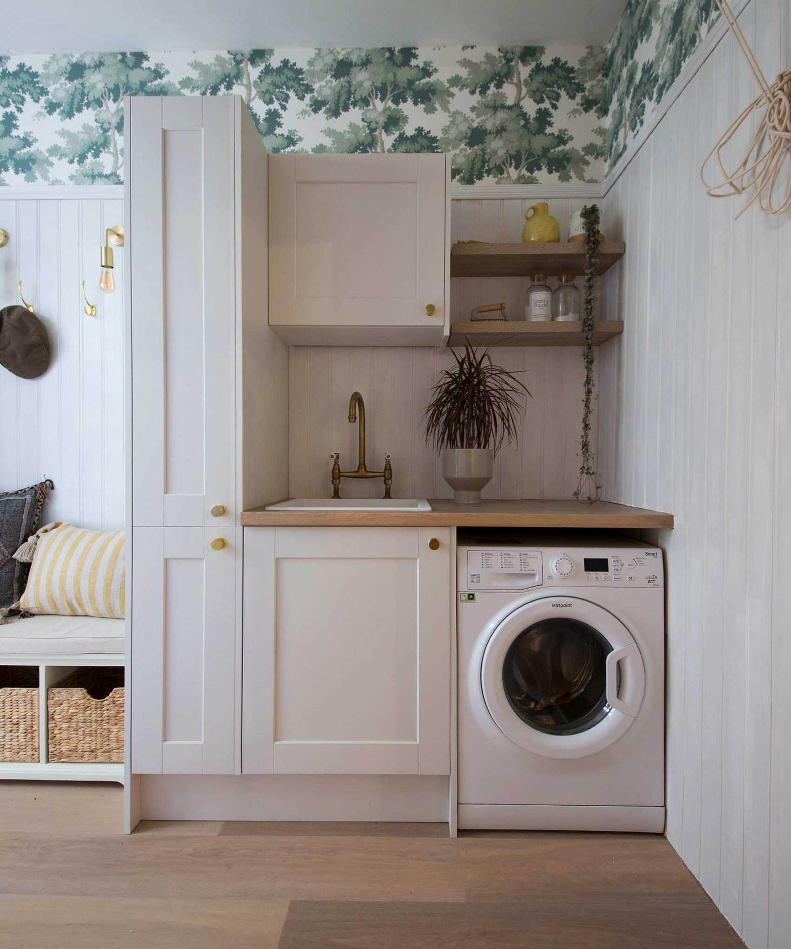 Industville Sleek Edison Wall Light - Brass image &amp;ndash; a neutral laundry room with green and white wallpaper, and an entryway bench to the left