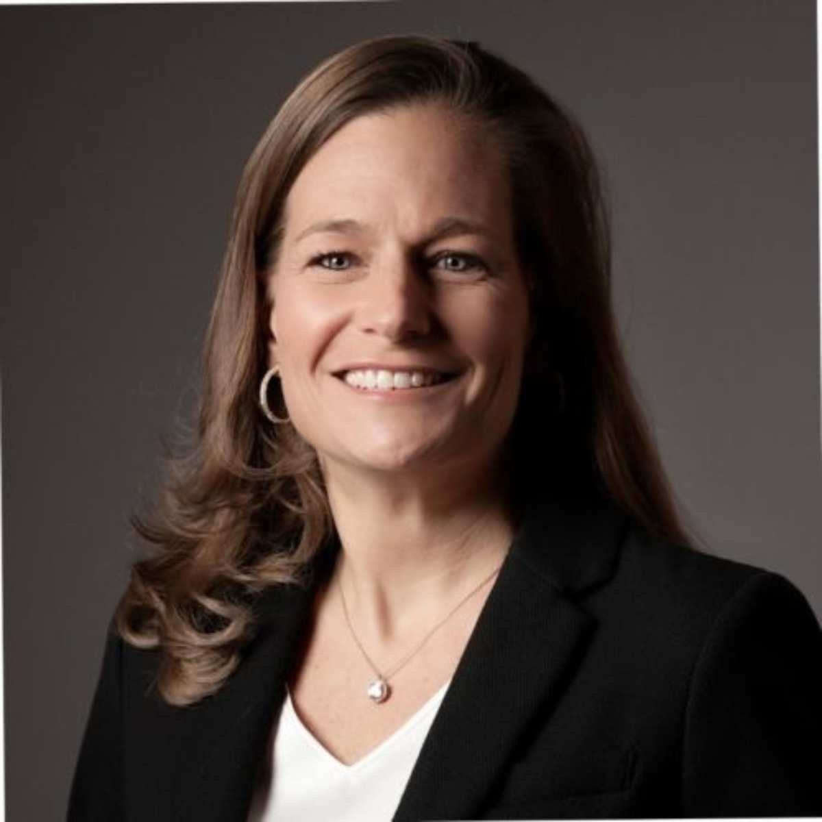 Marla Mock smiling in a headshot, with brown curly hair